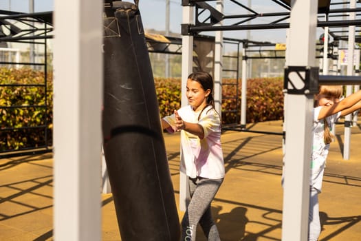 Young girl muay thai fighter working with the heavy bag. High quality photo