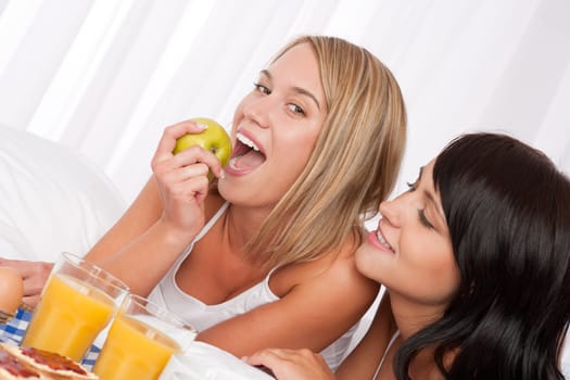 Lesbian couple have breakfast in bed