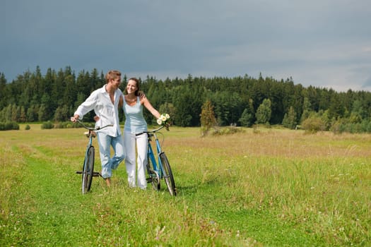 Summer - romantic couple with old-fashioned bike in nature