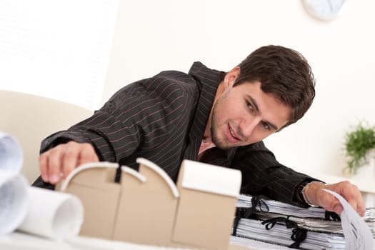 Successful architect working with architectural model