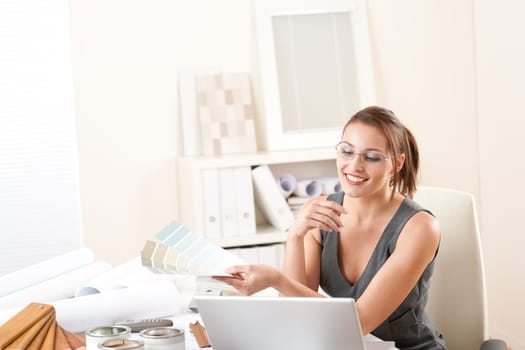Young female designer working at office with laptop
