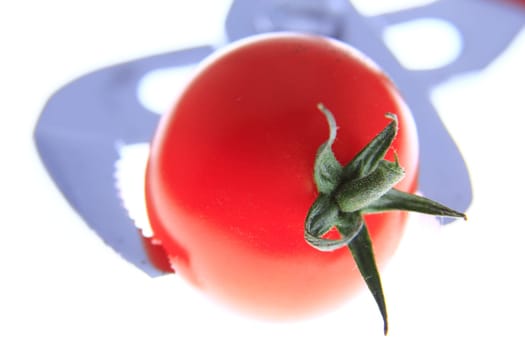 Tongs holding a tomato