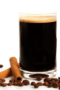 Espresso next to cinnamon and coffee beans