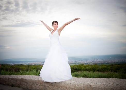 Bride jumping against blue sky