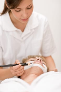 Male cosmetics - facial mask in salon