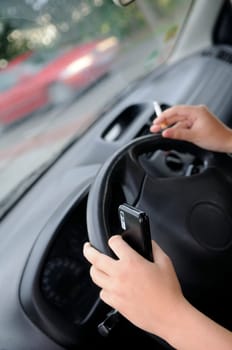 Cigarette and mobile phone on the steering wheel