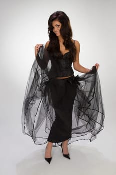 Beautiful girl in black dress on grey ba