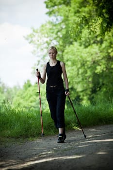 Nordic Walking - young woman is hiking