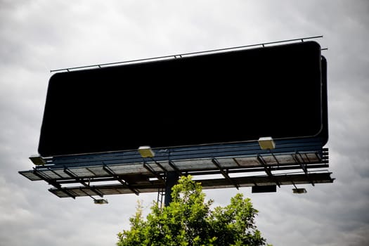 Black blank advertising billboard over sky