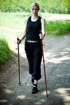 Nordic Walking - young woman is hiking