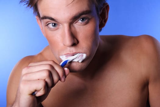 young man brushing his teeth
