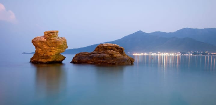 Two stones in the sea at dusk