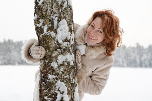 Portrait of happy red-haired woman in wi