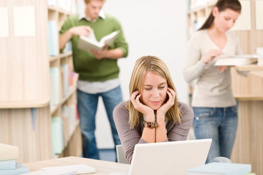 High school library - thoughtful student with laptop