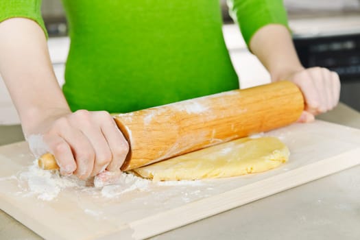 Hands with rolling pin and cookie dough