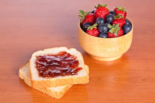 Two toast with jam, blueberries and strawberries