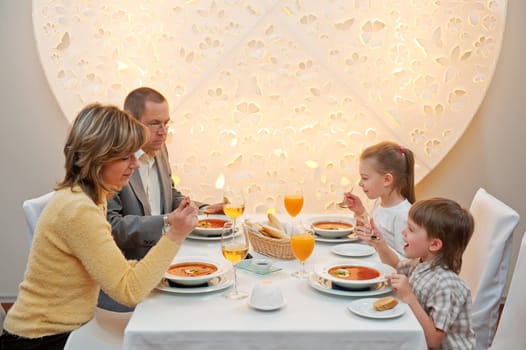 Happy family enjoying meal sitting at re