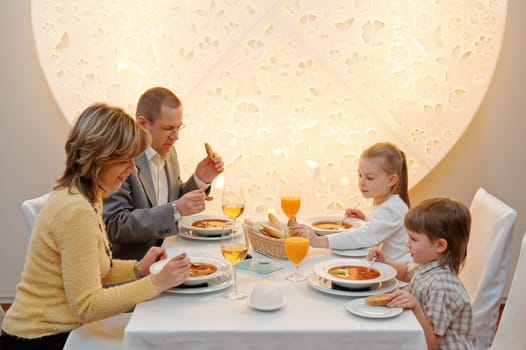Happy family enjoying meal sitting at re