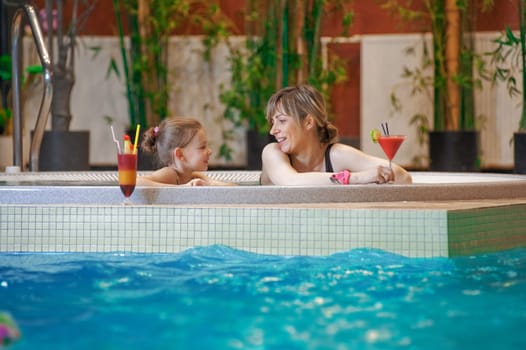 Happy mother and daughter relaxing by th