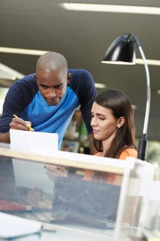 two students reviewing essay in library