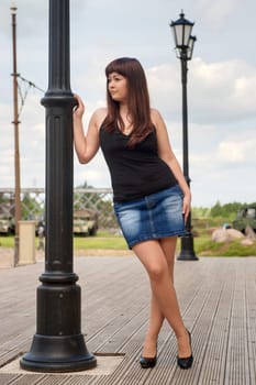 Young, sexy woman in short skirt leans o