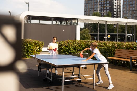 little girl playing table tennis in the tennis hall, tennis racket hitting the ball, the pitch of the ball. High quality photo