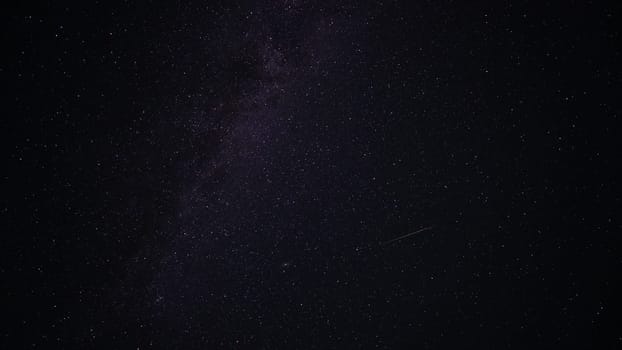 The Milky Way with falling meteorites. Space. A bright colored stripe is a trace of a meteorite. Nebulae and constellations are visible. Andromeda glows brightly. Astrophotography