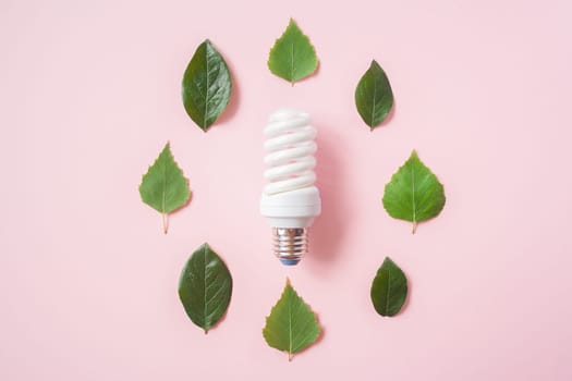 Light bulb with green leaves on pink background. Green Energy Concepts creative. Eco LED Lamp, environment sustainable. Sustainable Resources, Renewable and Environmental Care.