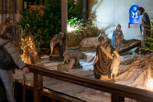 Father and daughter look at the Christmas nativity scene