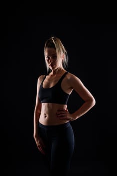 Beautiful young woman dressed in sports uniform, posing in the studio. Healthy lifestyle, sport