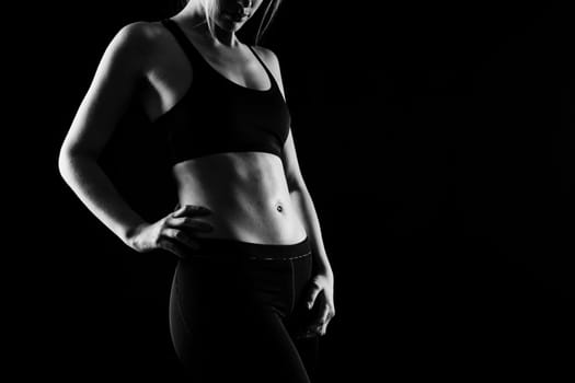 Beautiful young woman dressed in sports uniform, posing in the studio. Healthy lifestyle, sport