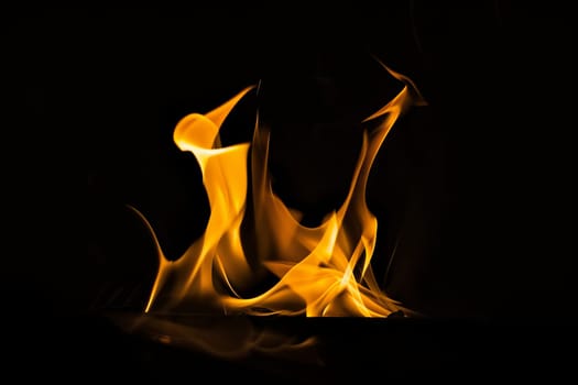Vivid yellow and orange flames dancing in dark background.