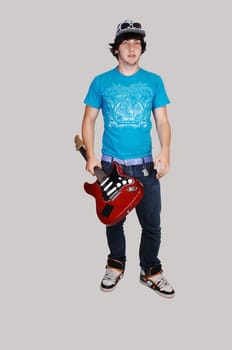 Boy standing with guitar.