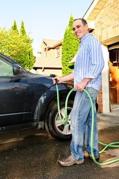 Man washing car on driveway