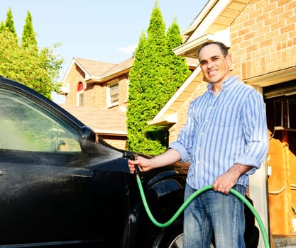 Man washing car on driveway
