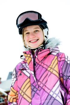 Happy girl in ski helmet at winter resort