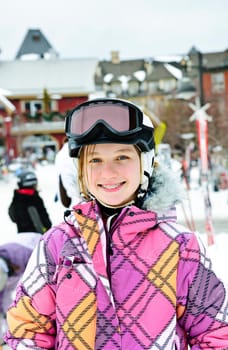 Happy girl in ski helmet at winter resort