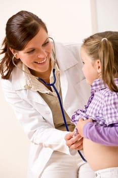 Female doctor examining child with stethoscope