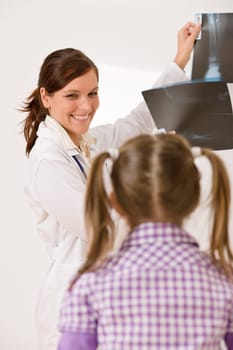 Young female doctor show x-ray to child