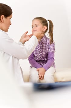 Female doctor examining child with sore throat