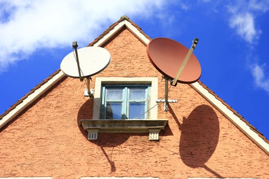 Two satellite dishes on a pediment