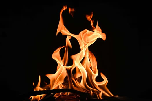 Vibrant orange flames against dark black background.