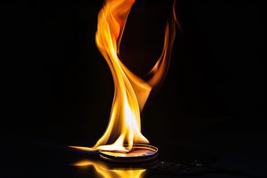 Vivid flames emanating from lighter against dark background.