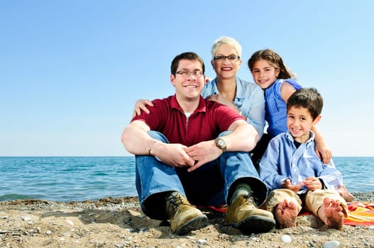 Happy family sitting at beach