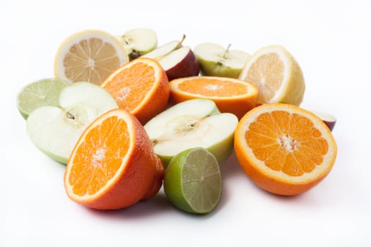 Group of cut citrus and apples on white