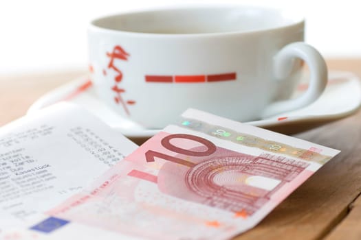 Teacup with receipt and banknote (no pr)