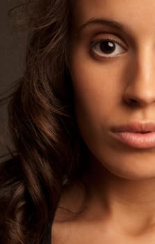 Young woman close-up portrait half face on dark background