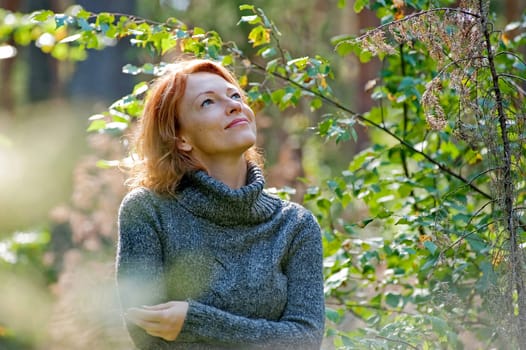 Portrait of red-haired adult woman in na