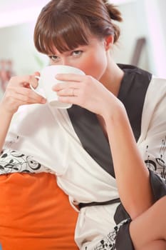 woman in bathrobe drinking tea