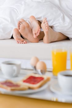 Luxury hotel honeymoon breakfast - couple in bed